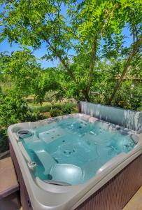 eine Whirlpool-Badewanne auf einer Terrasse mit Bäumen in der Unterkunft Villa Dvori Dida Mile in Sveti Petar