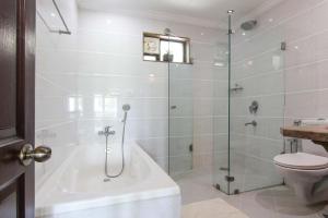 a bathroom with a shower and a tub and a toilet at Resort Coqueiral in Candolim