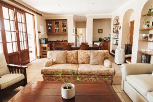 a living room with a couch and a table at Mitre's Edge Pool House in Klapmuts