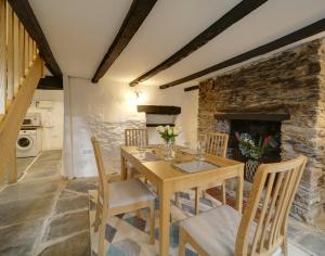 a dining room with a table and chairs and a fireplace at Dane Cottage in Port Isaac