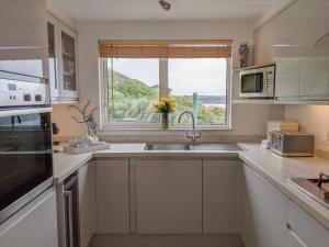 a kitchen with a sink and a window at Glenavon in Torpoint