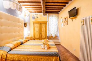 een slaapkamer met een bed met twee knuffels erop bij B&B Il sogno del musicista in Montalcino