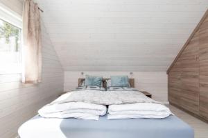 sypialnia z dużym łóżkiem z niebieskimi poduszkami w obiekcie Kotwica-Pobierowo Bukowa 1 w Pobierowie