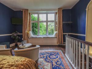 a bedroom with a bed and a window with a bench at Wisteria in Ambleside