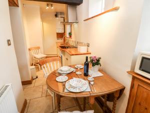a small kitchen with a wooden table with plates on it at The Kerr in Skipton