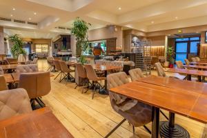 a restaurant with wooden tables and chairs at Hôtel The Originals City Le Berry - proche centre-ville - Gare in Bourges