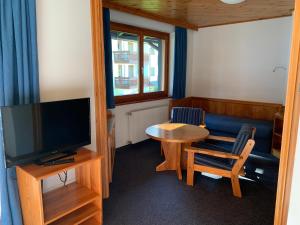 uma pequena sala de estar com uma televisão e uma mesa em Mai-Brunn Alm Appartements, Maibrunnenweg 34-36 em Bad Kleinkirchheim