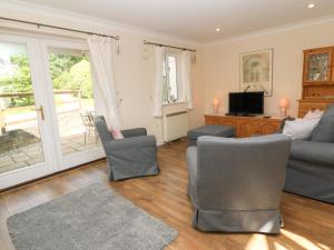 法爾茅斯的住宿－Blackbird Cottage，客厅配有沙发、椅子和电视
