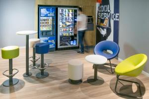 a group of chairs andools in front of a cooler at Hotel Ibis Budget Lyon Eurexpo - in Chassieu