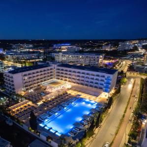 an aerial view of a hotel with a pool at night at Nestor Hotel in Ayia Napa
