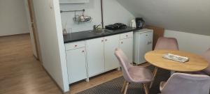 eine Küche mit einer Spüle sowie einem Tisch und Stühlen in der Unterkunft Central Palace Iași Apart 2 in Iaşi + 10 Fotos