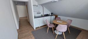 eine kleine Küche mit einem Tisch und lila Stühlen in der Unterkunft Central Palace Iași Apart 2 in Iaşi