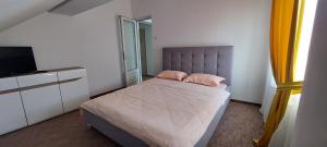 ein kleines Schlafzimmer mit einem Bett und einem Fernseher in der Unterkunft Central Palace Iași Apart 2 in Iaşi