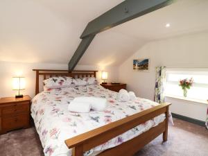 a bedroom with a large bed with two pillows at Wisteria Cottage in Paignton