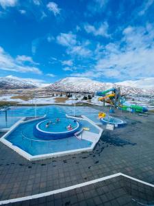 a swimming pool with snow covered mountains in the background at Beautiful house with amazing sea view. in Dalvík