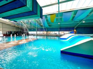 een zwembad met een glijbaan in een gebouw bij The Cove in Scarborough