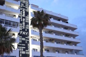 a hotel with a palm tree in front of it at FAY Victoria Beach in Rincón de la Victoria