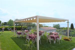 een patio met tafels en stoelen onder een luifel bij Albergo Panoramica in Bardolino