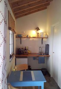 a kitchen with a blue table and a sink at Faial Cottage B&B in Cedros