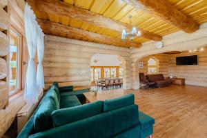 ein Wohnzimmer mit einem grünen Sofa und einem TV in der Unterkunft Casa din Deal in Mărişel