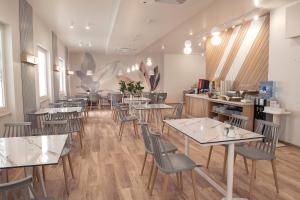 un restaurante con mesas y sillas en una habitación en Hotel Strass, en Paralia Katerinis