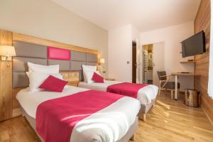 a hotel room with two beds and a television at La Bessannaise in Bessans +39 photos