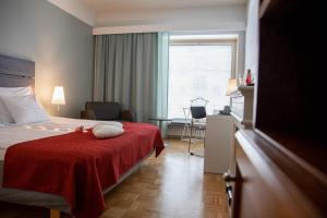 コッコラにあるHotel Kokkolaのホテルルーム ベッド1台(赤い毛布付)
