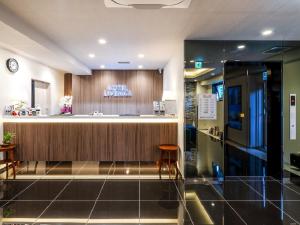 a hotel lobby with a counter and a bar at HOTEL LiVEMAX Okayama in Okayama