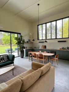 a living room with a couch and a table at La Maison dans l'Airial, maison d'architecte en pleine nature, PISCINE in Onesse-et-Laharie