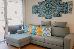 a couch with colorful pillows on it in a living room at Luxury Apartment Weisses Rössl Residenzen in Pörtschach am Wörthersee +12 photos