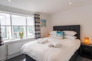 a bedroom with a large bed with towels on it at No.1 The Prom in Westward Ho