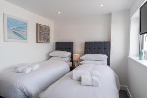 two beds sitting next to each other in a room at No.1 The Prom in Westward Ho