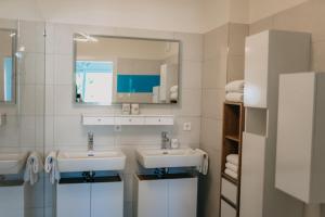 a bathroom with two sinks and a mirror at Luxury Apartment Weisses Rössl Residenzen in Pörtschach am Wörthersee