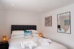 a bedroom with a white bed with towels on it at No.1 The Prom in Westward Ho