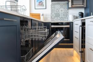 a dishwasher with dishes in it in a kitchen at No.1 The Prom in Westward Ho