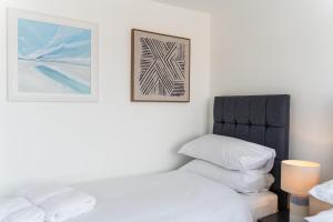 a bedroom with a bed and a picture on the wall at No.1 The Prom in Westward Ho