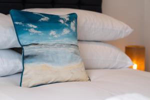 a pillow sitting on top of a bed with pillows at No.1 The Prom in Westward Ho