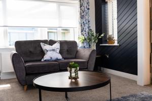 a living room with a couch and a coffee table at No.1 The Prom in Westward Ho