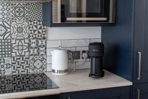 a kitchen counter with a coffee maker on a counter top at No.1 The Prom in Westward Ho