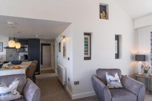 a kitchen and living room with chairs and a table at No.1 The Prom in Westward Ho