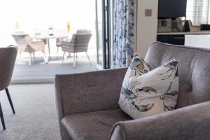 a pillow sitting on a couch in a living room at No.1 The Prom in Westward Ho