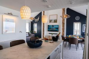 a kitchen and dining room with blue and white walls at No.1 The Prom in Westward Ho