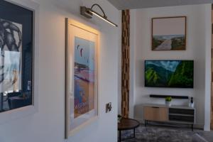 a living room with white walls and a tv at No.1 The Prom in Westward Ho