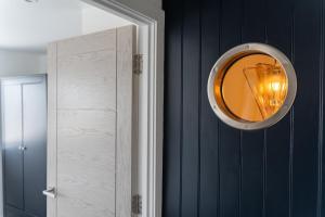 a mirror hanging on a wall next to a door at No.1 The Prom in Westward Ho