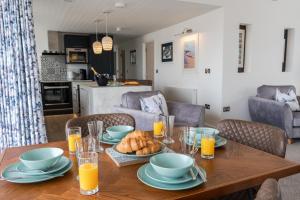 a table with a bowl of bread and glasses of orange juice at No.1 The Prom in Westward Ho