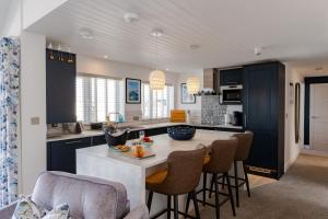 a kitchen with black cabinets and a table with chairs at No.1 The Prom in Westward Ho