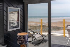 a screened in porch with a view of the beach at No.1 The Prom in Westward Ho
