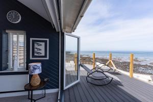 a house with a balcony with a view of the ocean at No.1 The Prom in Westward Ho
