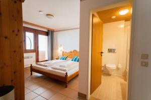 een slaapkamer met een bed en een badkamer bij Apartment Weitblick - Almresort Gerlitzen in Treffen