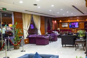a lobby with purple couches and televisions at Silent Room 1 By Quiet Rooms in Riyadh